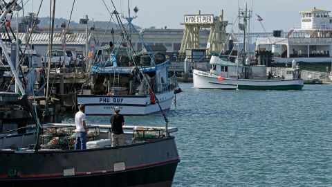 Fishermen stand on a boat loaded with crab pots, left, Thursday, Nov. 5, 2015, at Fisherman's Wharf in San Francisco. California officials are considering delaying the Dungeness crab season and closing the rock crab fishery just days after warning of dangerous levels of a neurotoxin linked to a massive algae bloom off the West Coast. (AP Photo/Ben Margot)