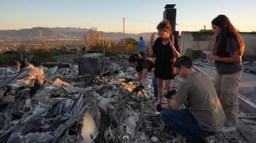 A family searches through debris at a home destroyed by the Mountain Fire in Camarillo, Calif., Friday, Nov. 8, 2024. (AP Photo/Jae C. Hong)