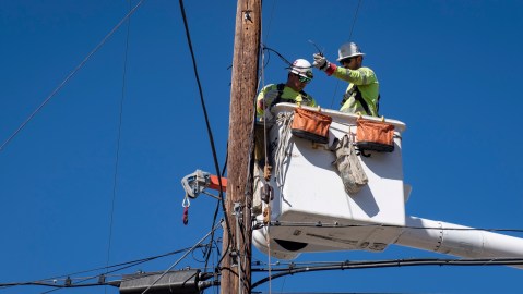 FILE - In this Oct. 25, 2019, file photo, Southern California Edison crews replace power lines that were damaged from the Tick Fire in Santa Clarita, Calif. Southern California Edison announced Sunday, Oct. 25, 2020, on its website it was considering safety outages for 75,000 customers in six Southern California counties. San Bernardino County was expected to be the most affected by those potential cuts. (AP Photo/ Christian Monterrosa, File)