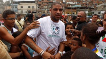 Italy's AS Roma's soccer player Adriano, of Brazil, is surrounded by children during the inauguration of community center Imperadores da Vila in the Vila Cruzeiro slum, his boyhood home, in Rio de Janeiro, Brazil, Wednesday Dec. 22, 2010. The center, funded by Adriano, is located in one of the slums raided by Brazilian police after five days of drug gang violence in November. (AP Photo/Felipe Dana)