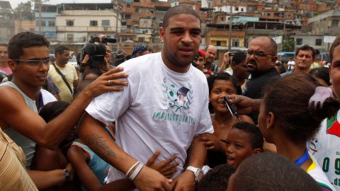 Italy's AS Roma's soccer player Adriano, of Brazil, is surrounded by children during the inauguration of community center Imperadores da Vila in the Vila Cruzeiro slum, his boyhood home, in Rio de Janeiro, Brazil, Wednesday Dec. 22, 2010. The center, funded by Adriano, is located in one of the slums raided by Brazilian police after five days of drug gang violence in November. (AP Photo/Felipe Dana)