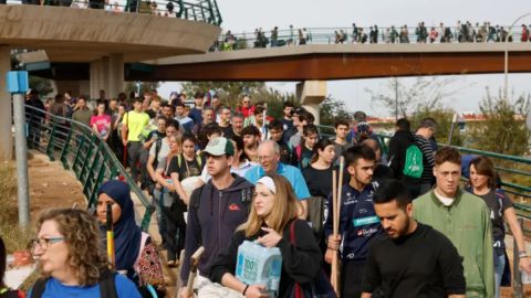 Miles de personas cruzan los puentes que conectan a la ciudad de Valencia con los municipios para llevar suministros y ayudar en las labores de limpieza.