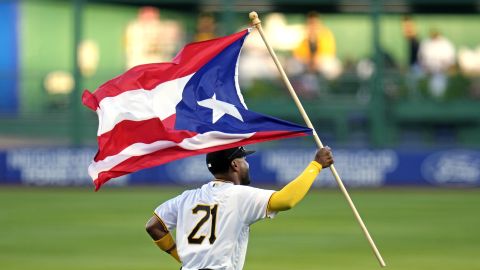 Pittsburgh Pirates right fielder Joshua Palacios carries the flag of Puerto Rico to his position in right field in honor of Roberto Clemente Day before a baseball game against the New York Yankees in Pittsburgh, Friday, Sept. 15, 2023. (AP Photo/Gene J. Puskar)