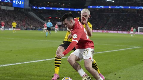 PSV's Hirving Lozano, right, vies for the ball with Dortmund's Julian Ryerson during the Champions League round of 16 first leg soccer match between PSV Eindhoven and Borussia Dortmund at Philips stadium in Eindhoven, Netherlands, Tuesday, Feb. 20, 2024. The match ended in a 1-1 draw. (AP Photo/Peter Dejong)