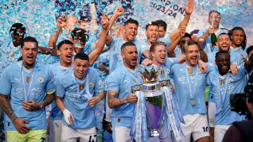 FILE - Manchester City's Kyle Walker celebrates with the Premier League trophy after the English Premier League soccer match between Manchester City and West Ham United at the Etihad Stadium in Manchester, England, Sunday, May 19, 2024. A fourth-straight Premier League title for Manchester City marks an unprecedented period of dominance by one team in English soccer. (AP Photo/Dave Thompson, File)