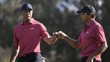 Tiger Woods choca el puño con su hijo Charlie en el PNC Championship.