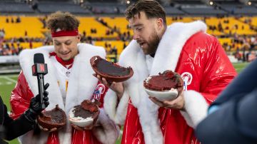 Patrick Mahomes y Travis Kelce, estrellas de los Chiefs en trajes de Santa Claus, comen pastel en forma de balones tras su victoria en Pittsburgh en el Día de Navidad.