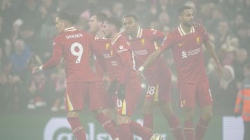 Liverpool's Cody Gakpo, right, celebrates with teammates after scoring his side's first goal against Leicester City during the English Premier League soccer match at the Anfield stadium in Liverpool, Thursday, Dec. 26, 2024. (AP Photo/Ian Hodgson)