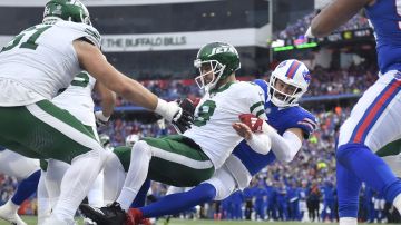 New York Jets quarterback Aaron Rodgers (8) is sacked by Buffalo Bills defensive end AJ Epenesa, right, in the end zone for a safety during the first half of an NFL football game, Sunday, Dec. 29, 2024, in Orchard Park, N.Y. (AP Photo/Adrian Kraus)