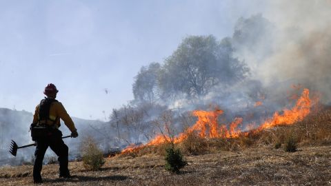 Trinh Nguyen, of the Camarillo Fire Dept, monitors the advance of the Easy Fire Wednesday, Oct. 30, 2019, in Simi Valley, Calif. Driven by powerful Santa Ana winds, the brush fire broke out before dawn between the cities of Simi Valley and Moorpark north of Los Angeles and exploded to more than 1,300 acres (526 hectares), threatening 6,500 homes, Ventura County officials said. (AP Photo/Marcio Jose Sanchez)