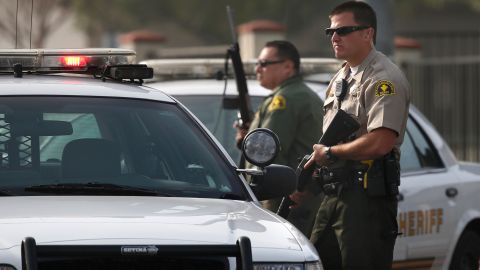 Two San Bernardino County sheriff's deputies stand guard near the area where a shooting took place in Riverside, Calif, Thursday, Feb. 7, 2013. Police launched a massive manhunt for a former Los Angeles officer suspected of going on a killing spree, slaying a couple over the weekend, opening fire on two Los Angeles officers early Thursday and then ambushing two other police officers, killing one. (AP Photo/Jae C. Hong)