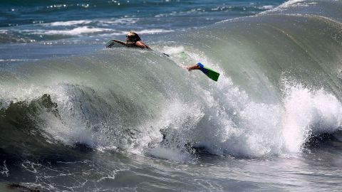 A body surfer swims through a wave at Seal Beach, Calif., Tuesday, Aug. 26, 2014. Residents in Southern California coastal areas filled sandbags and built sand berms Tuesday to ward against possible flooding from big and potentially damaging surf spawned by Hurricane Marie off Mexico's Pacific coast. A large southerly swell was expected to produce large waves, rip currents and strong longshore currents in Los Angeles and Ventura counties through Thursday, according to the National Weather Service. (AP Photo/Nick Ut)