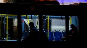 People wear face masks in a public bus in Frankfurt, Friday, Nov. 19, 2021. The government announced that the hospitalization rate will decide about further restrictions to avoid the outspread of the coronavirus. (AP Photo/Michael Probst)