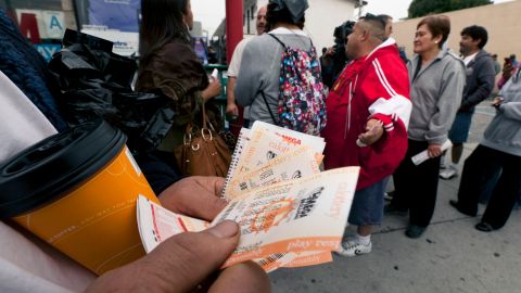 People line up to buy Mega Millions lottery tickets at the Bluebird Liquor store in Hawthorne, Calif. on Friday, March 30, 2012. Lottery ticket lines across the U.S. swelled Friday as players drawn by a record $640 million Mega Millions jackpot took a chance at becoming an overnight millionaire. The jackpot odds were at 1 in 176 million. (AP Photo/Damian Dovarganes)