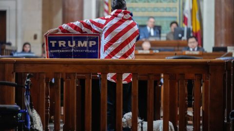 Protestor Herman Armando displays a Pro Trump sign during his public comment time, as members with immigration advocacy groups demand the City Council enact an ordinance making Los Angeles a sanctuary city in Los Angeles, Tuesday, Nov. 19, 2024. (AP Photo/Damian Dovarganes)