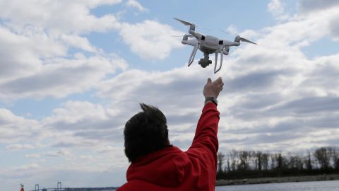 FILE - In this April 29, 2018, file photo, a drone operator helps to retrieve a drone after photographing over Hart Island in New York. (AP Photo/Seth Wenig, File)