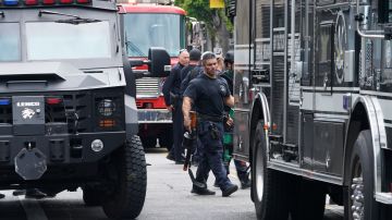 Los Angeles Police Department Special Weapons and Tactics (SWAT) team members leave following an hours-long standoff after a man fired a gun inside his apartment before barricading himself inside, Sunday, July 31, 2022, in the Hollywood district of Los Angeles. Officers responded around 7:30 a.m. to reports of gunfire on a residential block near the farmers market where vendors set up stalls every Sunday morning. Police closed several surrounding streets and shut down the market out of an abundance of caution. (AP Photo/Damian Dovarganes)