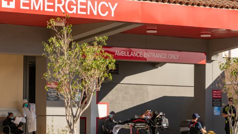 FILE - In this Dec. 18, 2020 file photo an unidentified patient receives oxygen on a stretcher, while Los Angeles Fire Department Paramedics monitor him outside the Emergency entrance, waiting for admission at the CHA Hollywood Presbyterian Medical Center in Los Angeles. California hospitals are facing increasingly difficult decisions about which services to postpone amid a crushing load of coronavirus patients. Intensive-care beds are full in Southern California and the Central Valley, with statewide availability at only 1.1%. (AP Photo/Damian Dovarganes,File)