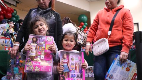 Lediy y su hermanita Isabella Pico, sonríen después de recibir sus regalos de Navidad.
