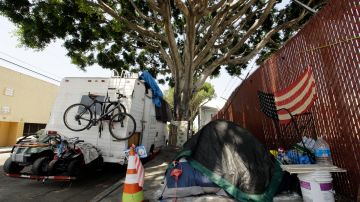 A RV vehicle is parked next to a tent on the streets in an industrial area of Los Angeles, Wednesday, July 31, 2019. Los Angeles has restored regulations barring people from sleeping at night in vehicles on residential streets or living anytime in vehicles within a block of parks, schools, preschools or daycare facilities. The City Council unanimously approved regulations Tuesday, July 30, that expired at the beginning of July. (AP Photo/Damian Dovarganes)