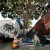 A RV vehicle is parked next to a tent on the streets in an industrial area of Los Angeles, Wednesday, July 31, 2019. Los Angeles has restored regulations barring people from sleeping at night in vehicles on residential streets or living anytime in vehicles within a block of parks, schools, preschools or daycare facilities. The City Council unanimously approved regulations Tuesday, July 30, that expired at the beginning of July. (AP Photo/Damian Dovarganes)