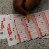 Prince Joseph Israel fills out Mega Millions playslips at Blue Bird Liquor in Hawthorne, Calif., Tuesday, July 26, 2022. (AP Photo/Jae C. Hong)