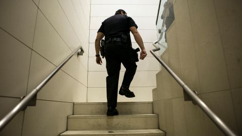 An unidentified Los Angeles police officer walks the stairs of the LAPD headquarters in Los Angeles Thursday, Feb. 7, 2013. Police launched a massive manhunt for a former Los Angeles officer suspected of going on a killing spree, slaying a couple over the weekend, opening fire on two Los Angeles officers early Thursday and then ambushing two other police officers, killing one.(AP Photo/Damian Dovarganes)