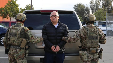 This undated photo provided by US Immigration and Customs Enforcement shows police officers holding drug lord Osiel Cárdenas Guillén. (US Immigration and Customs Enforcement via AP)