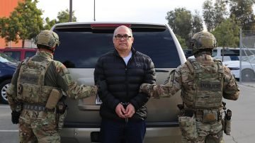 This undated photo provided by US Immigration and Customs Enforcement shows police officers holding drug lord Osiel Cárdenas Guillén. (US Immigration and Customs Enforcement via AP)