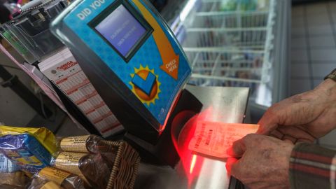 Roberto Ramirez checks his SuperLotto Plus ticket at a terminal at the gas station that previously sold the $2.04 billion-winning Powerball ticket award at Joe's Service Center, a Mobil gas station at Woodbury Road and Fair Oaks Avenue in Altadena, Calif., Friday, Jan. 6, 2023. Lottery players whose numbers didn't hit or who forgot to even buy a ticket will have another shot at a nearly $1 billion Mega Millions prize. The estimated $940 million jackpot up for grabs Friday night has been growing for more than two months and now ranks as the sixth-largest in U.S history. (AP Photo/Damian Dovarganes)