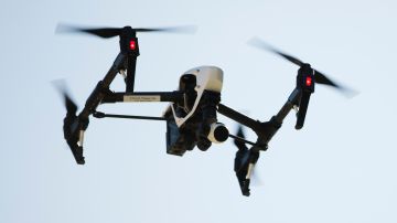 FILE - In this April 14, 2016 file photo, a drone captures videos and still images of an apartment building in Philadelphia. Federal aviation officials say so many people are registering drones and applying for drone pilot licenses, they wonder if there will eventually be millions of drones crowding the nation's skies. (AP Photo/Matt Rourke, File)