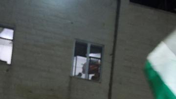Un hombre ondea banderas palestinas ante las noticias sobre un acuerdo de alto el fuego con Israel.