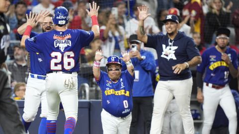 Venezuela's Hernan Perez (26) celebrates with teammates after he scored a run against the Dominican Republic during the fifth inning of the Caribbean Series finals baseball game, in Miami, Fla., Friday, Feb. 9, 2024. (AP Photo/Wilfredo Lee)