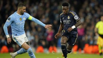 Manchester City's Kyle Walker fights for the ball with Real Madrid's Vinicius Junior during the Champions League quarterfinal second leg soccer match between Manchester City and Real Madrid at the Etihad Stadium in Manchester, England, Wednesday, April 17, 2024. (AP Photo/Dave Thompson)