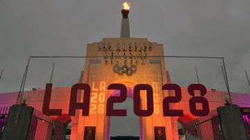 FILE - An LA 2028 sign is seen in front of the Olympic cauldron at the Los Angeles Memorial Coliseum on Sept. 13, 2017. (AP Photo/Richard Vogel, File)