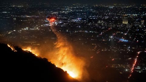 Un helicóptero arroja agua sobre el incendio de Sunset en la zona de Hollywood Hills de Los Ángeles.