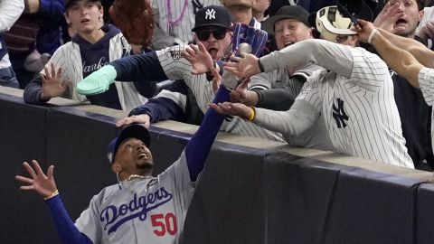 FILE - Fans interfere with a foul ball caught by Los Angeles Dodgers right fielder Mookie Betts during the first inning in Game 4 of the baseball World Series against the New York Yankees, Tuesday, Oct. 29, 2024, in New York. (AP Photo/Ashley Landis, File)