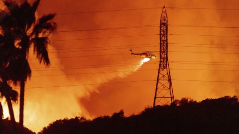 Un helicóptero realiza una descarga de agua sobre el incendio Palisades cerca de Mandeville Canyon en las Montañas Santa Mónica durante la positiva jornada del viernes.