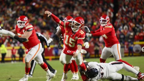 Kansas City Chiefs quarterback Patrick Mahomes (15) throws a touchdown pass to Travis Kelce while being tackled by Houston Texans defensive tackle Mario Edwards Jr. (97) during the second half of an NFL football divisional playoff game, Saturday, Jan. 18, 2025 in Kansas City, Mo. (AP Photo/Reed Hoffmann)