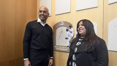 ARCHIVO - Mariano Rivera, miembro del Salón de la Fama del béisbol, y su esposa Clara Rivera, frente al sitio de su placa, el 1 de febrero de 2019, en Cooperstown, Nueva York. (AP Foto/Hans Pennink)