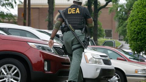 A Drug Enforcement Administration officer patrols outside of a medical clinic in Little Rock, Ark., Wednesday, May 20, 2015. The DEA was wrapping up a multistate crackdown on prescription drug abuse with raids at pain clinics, pharmacies and other locations in the South. (AP Photo/Danny Johnston)