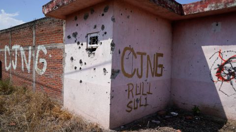 The letters “CJNG” for the group’s formal name, Jalisco New Generation Cartel, are scrawled on the facade of an abandoned home, in El Limoncito, in the Michoacan state of Mexico, Saturday, Oct. 30, 2021. The cartel based in Jalisco state is invading neighboring Michoacan, causing thousands of farmers to flee, with some seeking asylum in the United States. (AP Photo/Eduardo Verdugo)