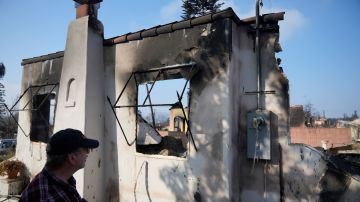 Joel Parkes, a teacher at Los Angeles Unified School District returns to his destroyed home in the aftermath of the Eaton Fire, Sunday, Jan. 19, 2025, in Altadena, Calif. (AP Photo/Damian Dovarganes)