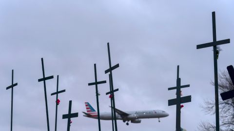 An American Airlines plane prepares to land at Ronald Reagan Washington National Airport as crosses are seen in a makeshift memorial for the victims of the plane crash in the Potomac River Friday, Jan. 31, 2025, in Arlington, Va. (AP Photo/Jose Luis Magana)