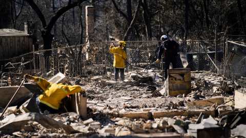 A search and rescue crew sifts through the wreckage of a home destroyed by the Eaton Fire, Tuesday, Jan. 14, 2025, in Altadena, Calif. (AP Photo/John Locher)