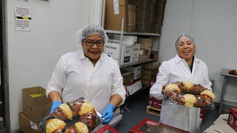 Isabel Cortés y Gabriela Gonzalez envuelven en plástico transparente las Roscas de Reyes y después las empaquetan.