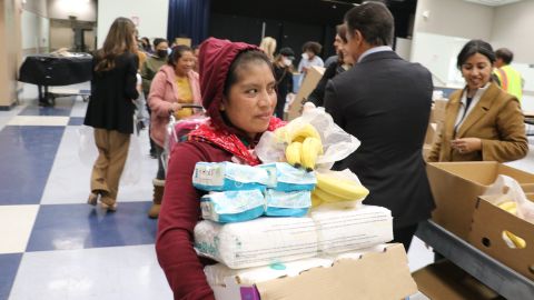 Esta madre de familia apenas puede cargar la despensa de comida que llevó a su casa.