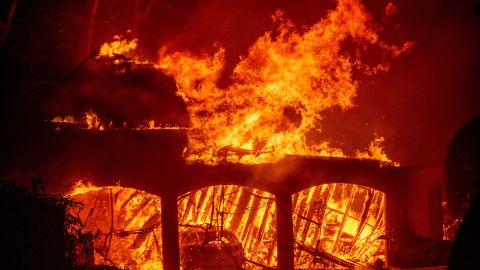 The Eaton Fire burns a residence Wednesday, Jan. 8, 2025 in Altadena, Calif. (AP Photo/Ethan Swope)