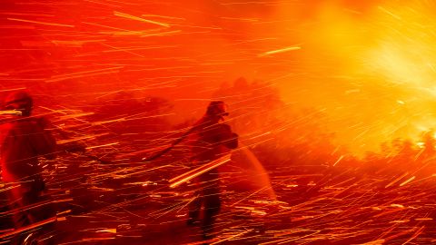 Firefighter Joshua Cari sprays water while battling the Lilac Fire near the Bonsall community of San Diego County, Calif., on Tuesday, Jan. 21, 2025. (AP Photo/Noah Berger)