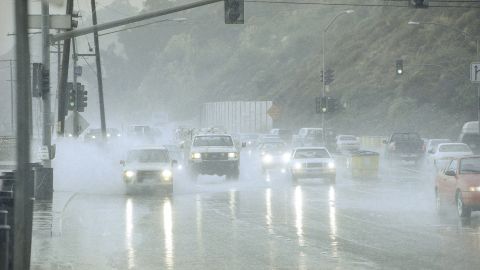 Cars and trucks put up plumes of water as they hit deep spots on Pacific Coast Highway at Chautauqua Boulevard in the Pacific Palisades district of Los Angeles on Thursday, Nov. 13, 1997 during a short period of heavy rain. A rain and snow system swept through Southern California for the second time in three days. (AP Photo/Reed Saxon)